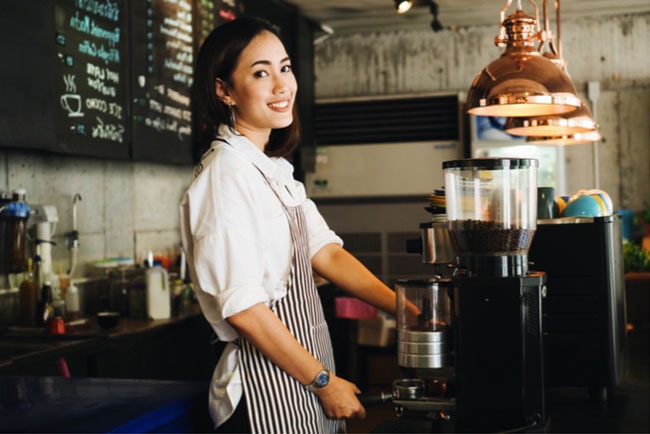 En bild på en ung tjej som arbetar på café